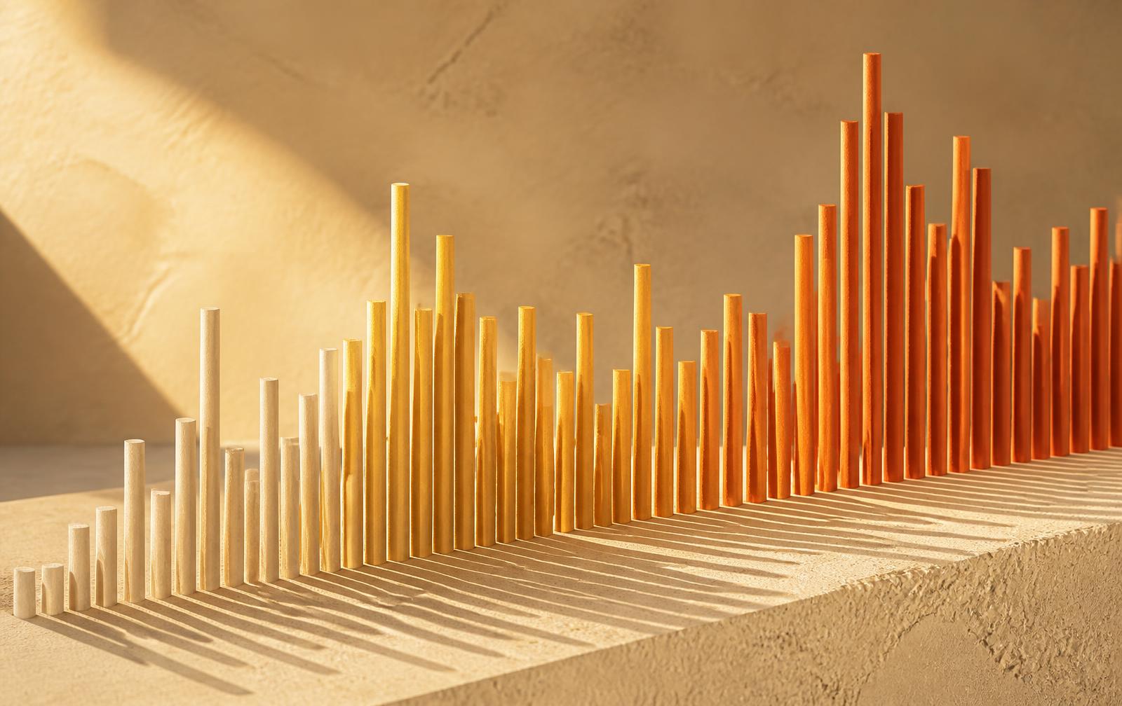 Rows of wooden rods of varying heights forming an abstract chart in sunset colours
